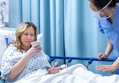 Patient in hospital bed drinking coffee